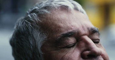 Yaşlı adam meditasyonda ve tefekkür ederken gözlerini kapatıyor.