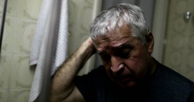 Yaşlı bunalımlı ihtiyar, banyo aynasının önünde.