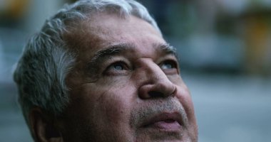 Orta yaşlı yaşlı bir adamın yüzü yukarı bakıyor.