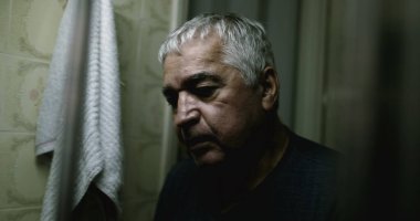 Aynanın önünde depresif yaşlı adam.