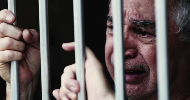 Parmaklıklar ardındaki umutsuz yaşlı adam. Hapisteki kişi