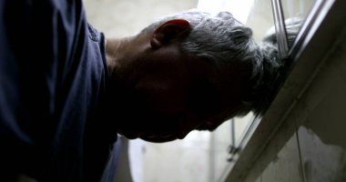 Çaresiz, bunalımdaki yaşlı adam aynaya bakıyor.