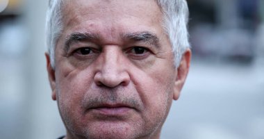 Sıradan bir ihtiyar dışarıda kameraya bakıyor. Kıdemli orta yaşlı kişi