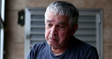 Kızgın, üzgün, orta yaşlı adam ağlıyor, gözyaşlarını siliyor.