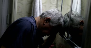 Stresli yaşlı adam banyo aynasının önünde. Orta yaş krizi