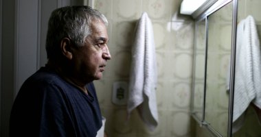 Stresli yaşlı adam banyo aynasının önünde. Orta yaş krizi