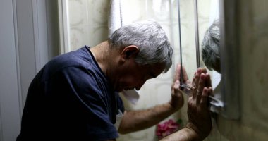 Stresli yaşlı adam banyo aynasının önünde. Orta yaş krizi