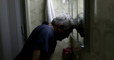 Stresli yaşlı adam banyo aynasının önünde. Orta yaş krizi
