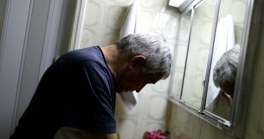 Stresli yaşlı adam banyo aynasının önünde. Orta yaş krizi