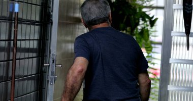 Yaşlı adam evin kapısını açarak dışarı çıkıyor.