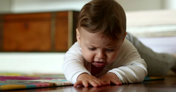 Baby infant development lying on floor learning to move and crawl