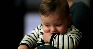 Geceleri pijama giyen sevimli bir bebek. Anne kucağında bebek var.