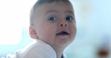 Bebek yatakta uzanmış gülümsüyor.