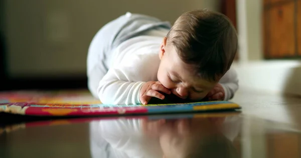 Baby learning to crawl in living-room floor. Cute toddler infant cild grabbing object