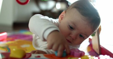 Çorapla oynayan şirin bir bebek, ağzına giysi koyan sevimli bir bebek portresi.