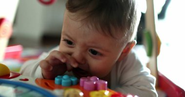 Bebek odasında yerde duran sevimli bebek portresi. Bebek yüzlü, çocuk yüzlü.