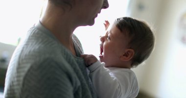 Bebek nöbeti. Anne kucağında ağlayan bebek gelişigüzel yürüyor.
