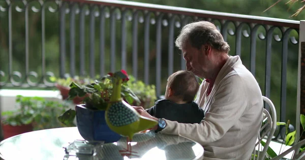 Candid grand-father with baby grand-son in balcony