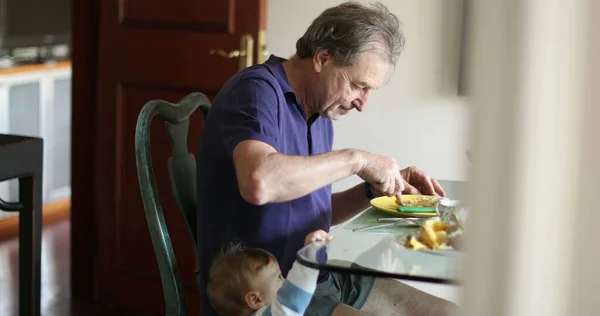 Candid Baby Standing Next Grandpa While Eating Morning Breakfast — Foto de Stock