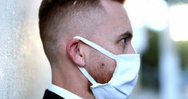 Dışarıda salgın maskesi takan bir adam var.