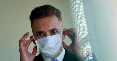 Adam salgından sonra Covid-19 yüz maskesi çıkartıyor.