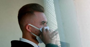 Adam ameliyat maskesini takıyor. Virüse karşı yüz maskesi takan kişi