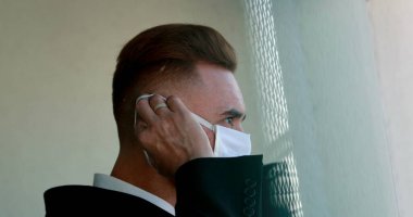 Adam ameliyat maskesini takıyor. Virüse karşı yüz maskesi takan kişi