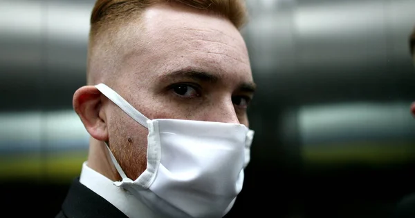 Man putting on face mask inside elevator mirror, person wearing covid-19 surgical mask to go outside