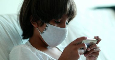 Çocuk salgın sırasında video oyunu oynuyor