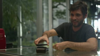 Akıllı telefon cihazıyla ödeme yapan kişi. NFC nakitsiz ödeme teknolojisini kullanarak cep telefonu kullanıyor.