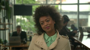 Bir bayan müşteri kahve tezgahında sırıtarak siparişin gelmesini bekliyor.