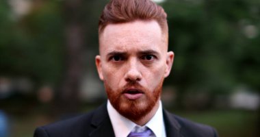 İş adamı kamera görüntüsü ile tartışıyor. İrlandalı görünümlü şirket yöneticisi tartışmada kameraya konuşuyor