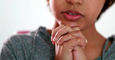 Çocuk ellerini birleştirip Tanrı 'ya dua ediyor. Karışık ırk çocuğu gözleri kapalı ruhani dua eder.