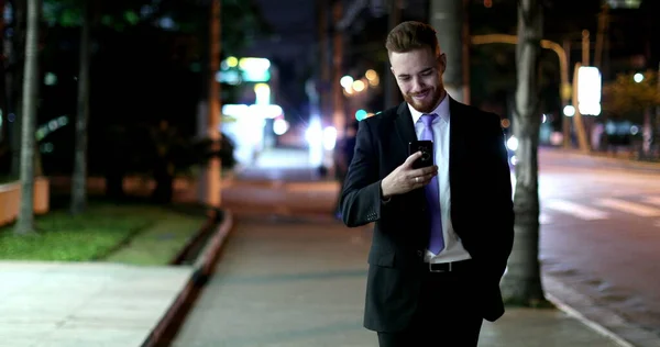 Homem Negócios Olhando Para Dispositivo Celular Noite Andando Calçada — Fotografia de Stock
