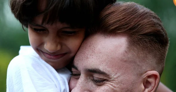 Beautiful tender moment between father and child son outside, ethnically diverse family