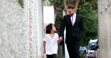 Güzel baba ve melez oğul şehir kaldırımında birlikte yürüyorlar, ebeveyn ve etnik çeşitlilikte genç çocuk kaynaşıyor.