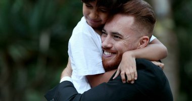 Güzel çocuk ve baba kucaklaşır, melez oğul babaya sarılır, gerçek aşk ve bakım ilişkisi