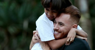 Güzel çocuk ve baba kucaklaşır, melez oğul babaya sarılır, gerçek aşk ve bakım ilişkisi