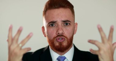 Kızgın adam kameraya konuşuyor, İrlandalı görünüşlü biri tartışıyor.