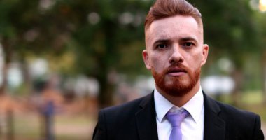 Kızgın iş adamı dışarıda kameraya karşı tartışıyor. Tartışmada yönetici üzgün