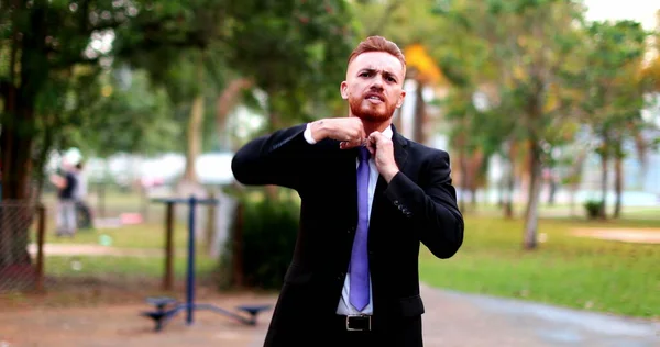 Angry business man standing arguing to camera outside. Upset executive in argument