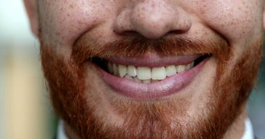 Yakın plan erkek ağzı gülümsüyor. Kızıl saçlı, kızıl saçlı, gülümseyen, yakından bak.