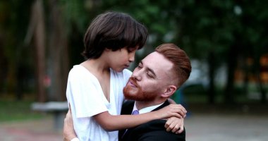 Oğlunun baba yanağını öptüğü sevgi dolu bir an. Etnik çeşitlilikte aile ve çocuk sevgisi ve bakımı