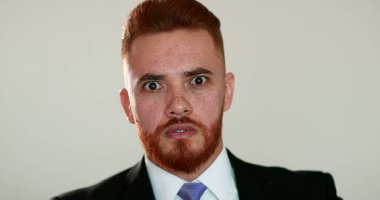 İş adamı şok reaksiyonu. Takım elbiseli yakışıklı adam şaşırmış gözlerle tepki veriyor.