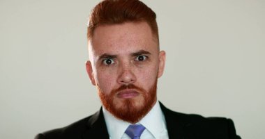 İş adamı şok reaksiyonu. Takım elbiseli yakışıklı adam şaşırmış gözlerle tepki veriyor.