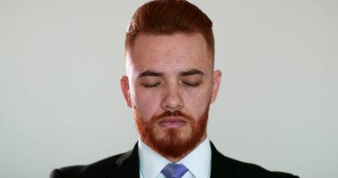 Yakışıklı iş adamı kameraya bakıp gülümsüyor. kızıl saçlı kişi.