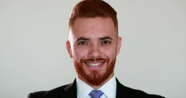 Yakışıklı iş adamı kameraya bakıp gülümsüyor. kızıl saçlı kişi.