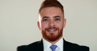 Girişimci genç adam kameraya bakıp gülümsüyor.