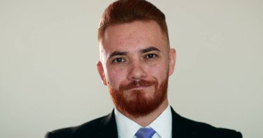 Girişimci genç adam kameraya bakıp gülümsüyor.