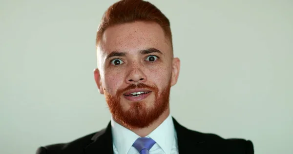 Handsome business man redhead hearing good news smiling in surprise to camera portrait